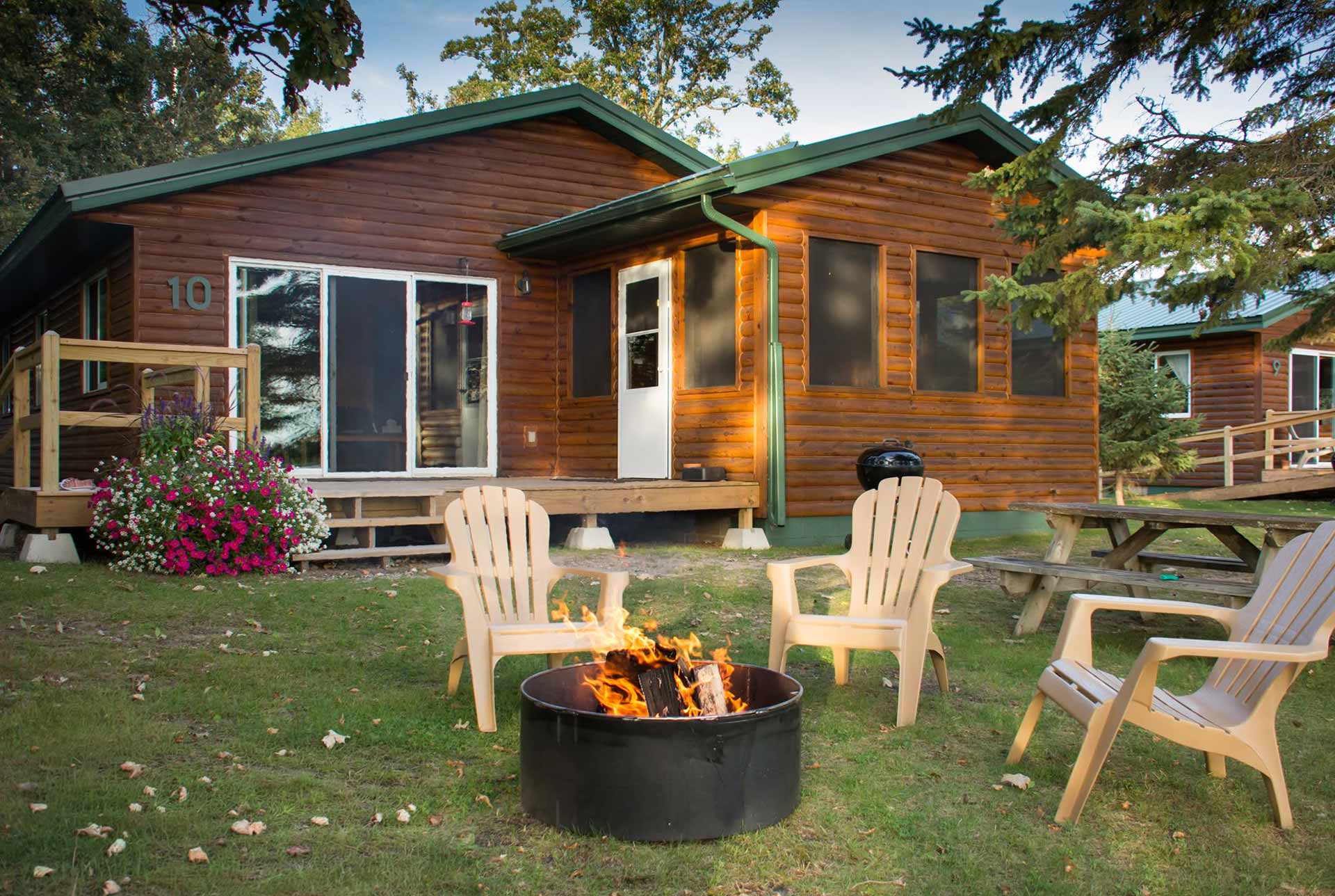 Cozy wooden cabin with fire pit and chairs