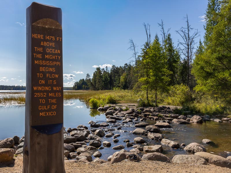 Mississippi River headwaters sign by rocky stream